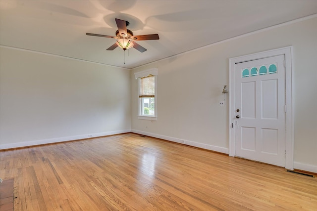 entryway with light wood finished floors, ceiling fan, baseboards, and crown molding