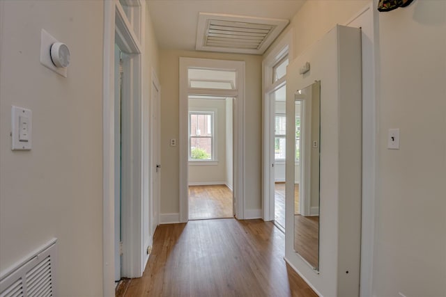 corridor featuring wood finished floors and baseboards