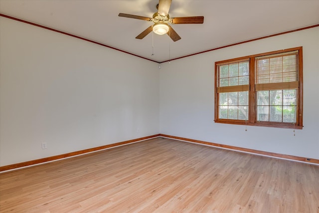 spare room with baseboards, light wood finished floors, ceiling fan, and crown molding