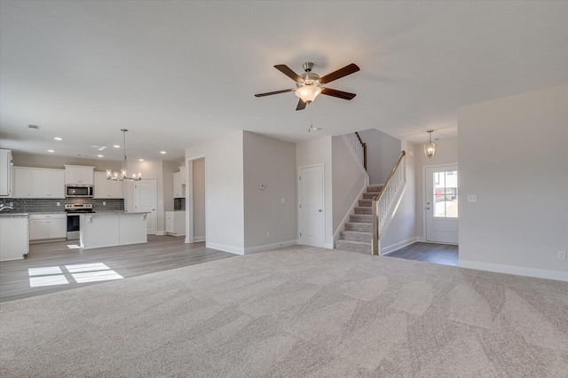 1282 Elias Sta, Thomson, GA 30824 - unfurnished living room with light colored carpet, a chandelier, stairway, baseboards, and recessed lighting