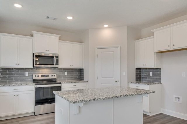 1282 Elias Sta, Thomson, GA 30824 - kitchen featuring stainless steel appliances, wood finished floors, white cabinetry, decorative backsplash, and recessed lighting