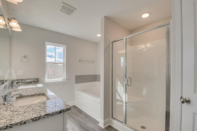 1282 Elias Sta, Thomson, GA 30824 - bathroom featuring wood finished floors, a bath, a shower stall, and double vanity