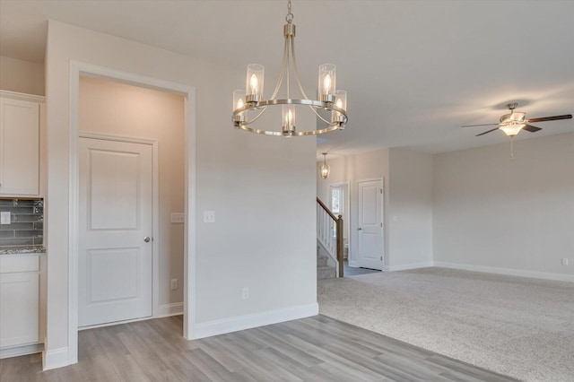 1282 Elias Sta, Thomson, GA 30824 - empty room featuring stairs, a chandelier, light wood finished floors, a ceiling fan, and baseboards