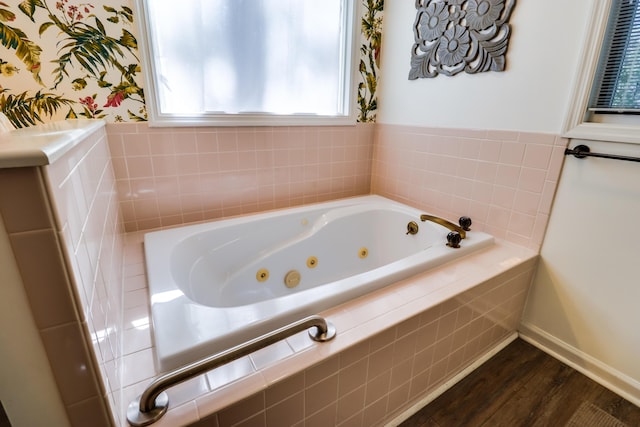 bathroom featuring tiled bath and hardwood / wood-style floors