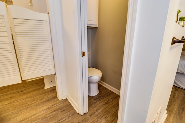 bathroom with hardwood / wood-style floors and toilet