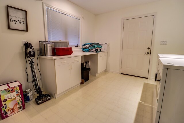 clothes washing area featuring cabinets and washing machine and clothes dryer