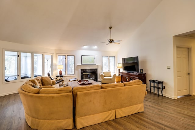 living room featuring high vaulted ceiling, ceiling fan, dark wood-type flooring, and a tiled fireplace