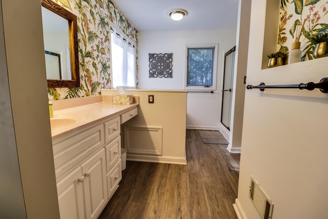 bathroom featuring hardwood / wood-style flooring, vanity, and walk in shower