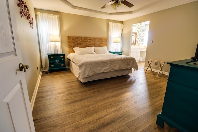 bedroom featuring hardwood / wood-style floors, a tray ceiling, and ceiling fan