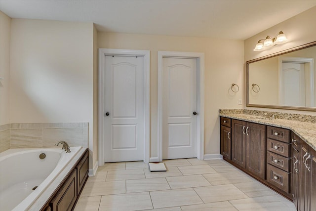 bathroom featuring vanity and a washtub