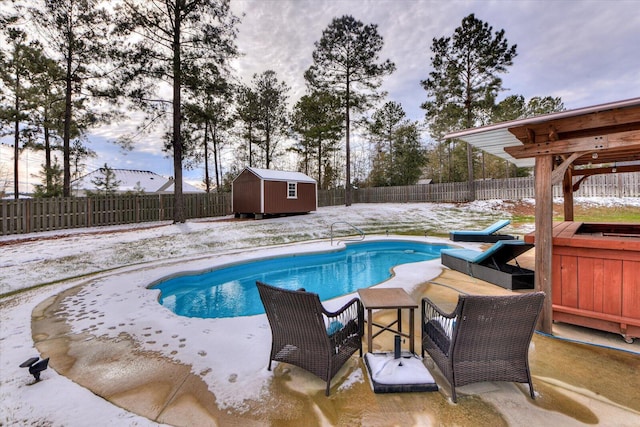 snow covered pool with a storage shed