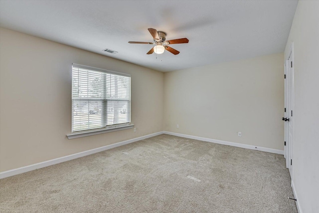 carpeted spare room with ceiling fan