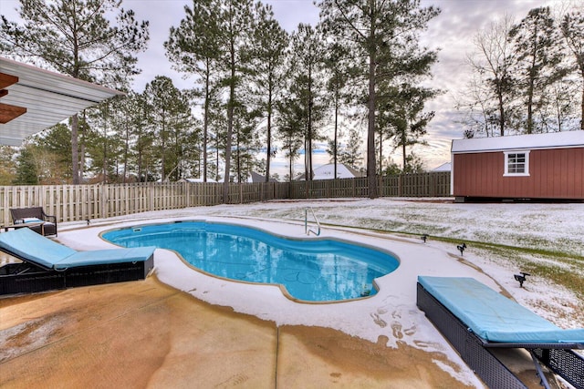 view of swimming pool with a patio area and a shed