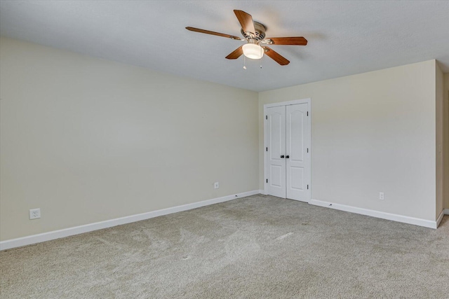 spare room featuring ceiling fan, light colored carpet, and a textured ceiling