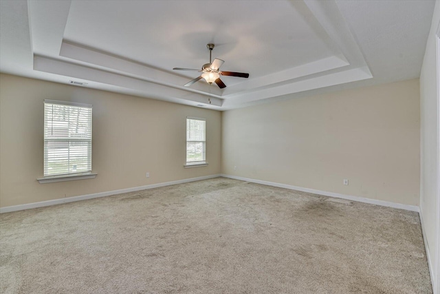 carpeted empty room featuring ceiling fan and a tray ceiling