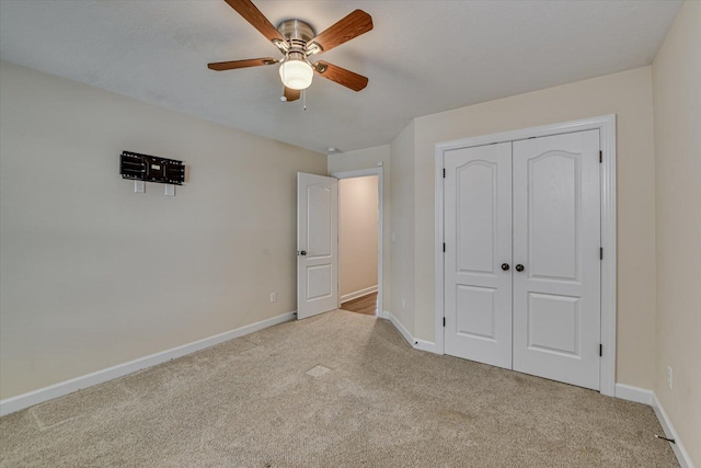 unfurnished bedroom with light carpet, ceiling fan, and a closet