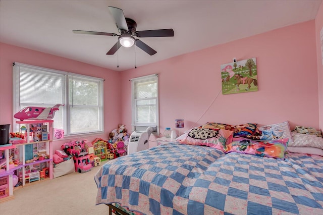 carpeted bedroom with ceiling fan and multiple windows