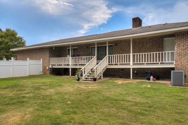 back of house featuring a lawn and central AC