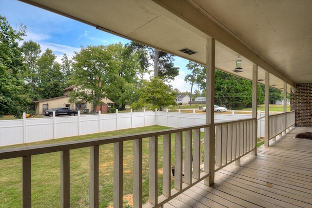 wooden terrace with a porch and a lawn