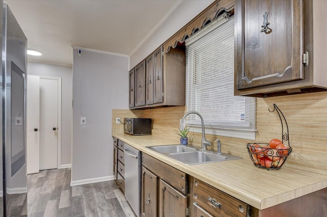 kitchen with crown molding, sink, stainless steel dishwasher, decorative backsplash, and light hardwood / wood-style floors