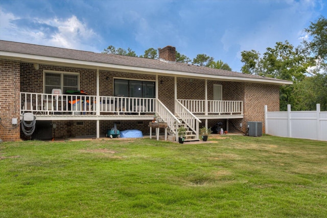 rear view of house featuring a yard and central AC unit