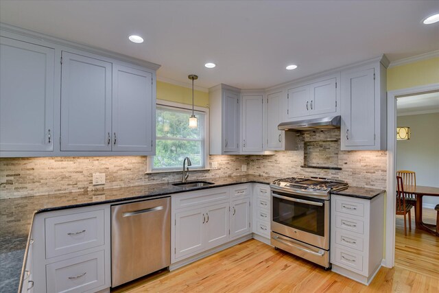 802 Dunbarton Dr, North Augusta, SC 29841 - kitchen featuring appliances with stainless steel finishes, ornamental molding, light wood-style floors, dark stone counters, and backsplash