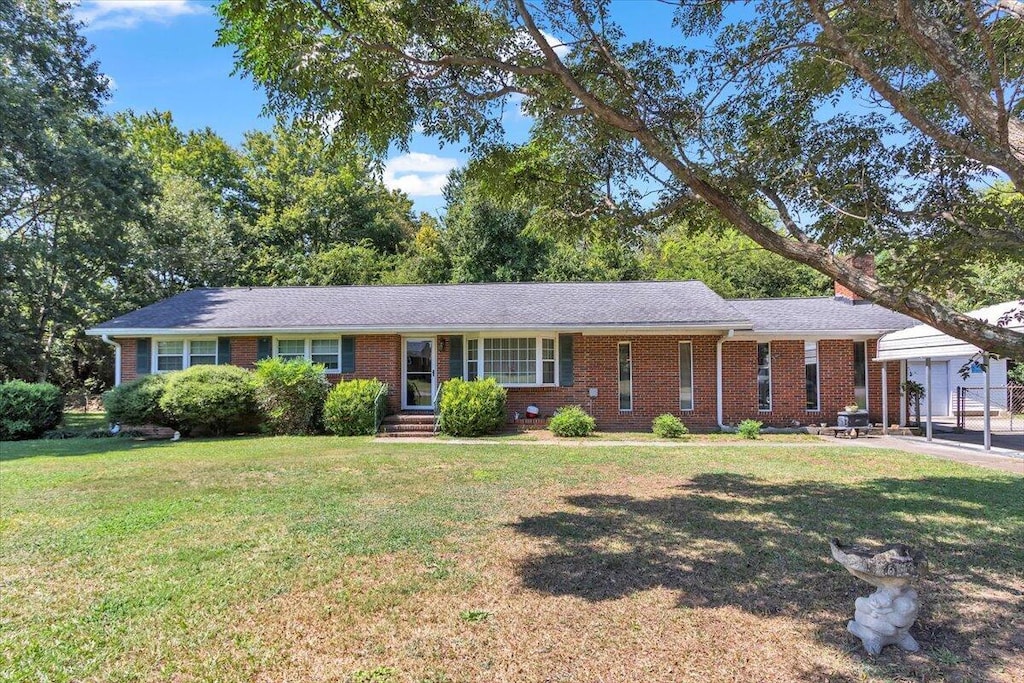 ranch-style home featuring a garage and a front lawn