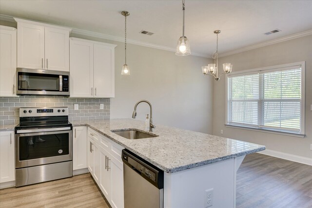 5816 Whispering Pines Way, Evans, GA 30809 - kitchen featuring appliances with stainless steel finishes, a sink, light wood-style floors, a peninsula, and ornamental molding