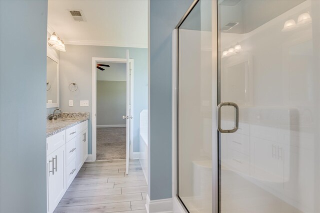 5816 Whispering Pines Way, Evans, GA 30809 - full bathroom featuring double vanity, a stall shower, wood finished floors, crown molding, and a tub to relax in