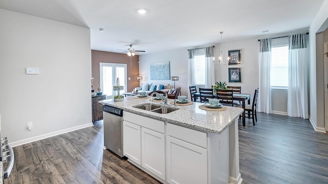 kitchen with dishwasher, a center island with sink, sink, white cabinets, and ceiling fan with notable chandelier