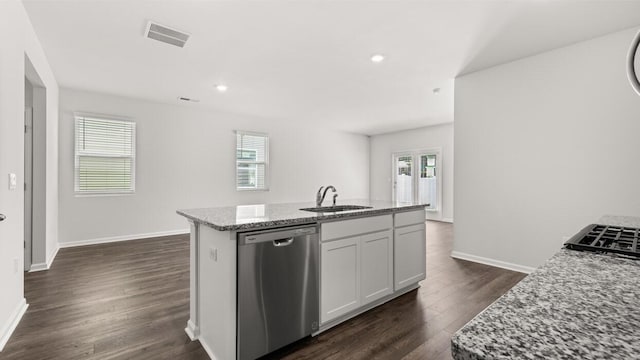 kitchen featuring light stone counters, visible vents, dark wood-style flooring, a sink, and stainless steel dishwasher