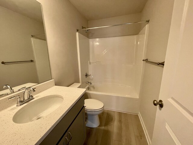 full bathroom with vanity, toilet, wood-type flooring, and bathing tub / shower combination