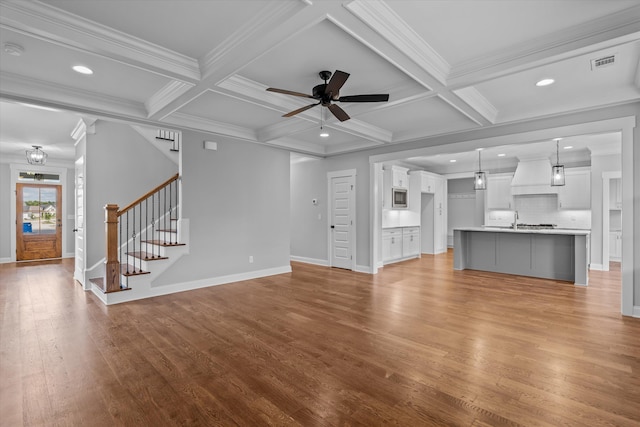 831 Whitney Shoals Rd, Evans, GA 30809 - unfurnished living room featuring crown molding, stairs, light wood-style flooring, a ceiling fan, and beamed ceiling