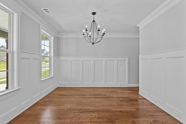 831 Whitney Shoals Rd, Evans, GA 30809 - unfurnished dining area with a decorative wall, a chandelier, crown molding, wood finished floors, and a wainscoted wall