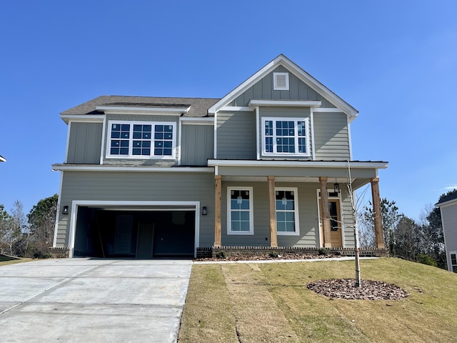 view of front of home featuring a garage, a front yard, and a porch