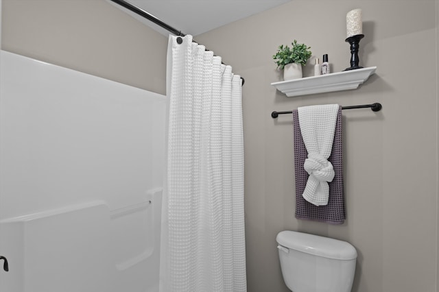 bathroom featuring curtained shower and toilet