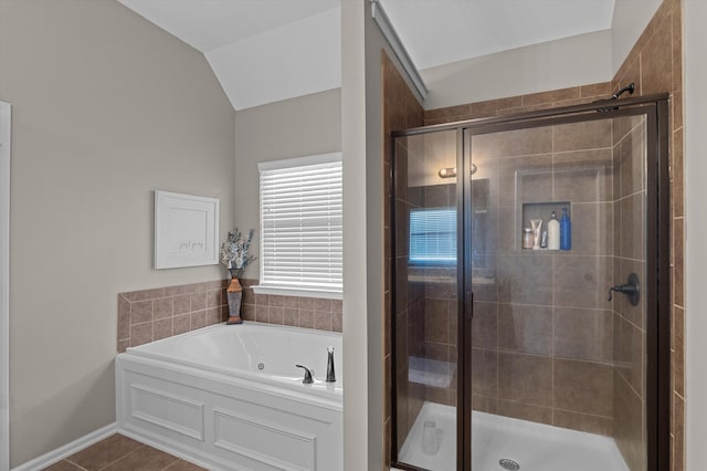 bathroom with a stall shower, a garden tub, tile patterned flooring, and lofted ceiling