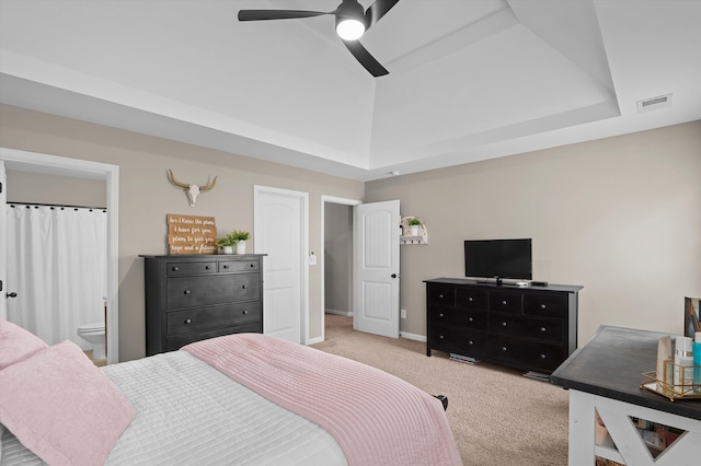 bedroom featuring light colored carpet, baseboards, a ceiling fan, and a raised ceiling