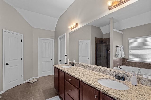 full bath featuring a shower stall, vaulted ceiling, tile patterned flooring, double vanity, and baseboards