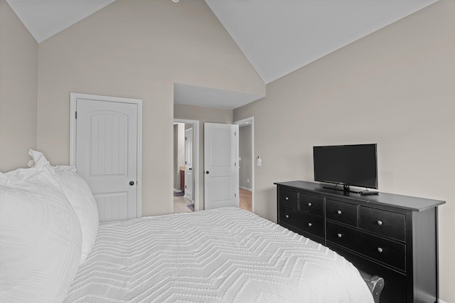 bedroom with high vaulted ceiling and baseboards