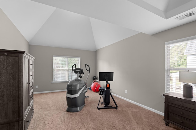 exercise room with light carpet, baseboards, and vaulted ceiling