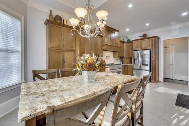 kitchen with pendant lighting, decorative backsplash, stainless steel fridge, a breakfast bar area, and a chandelier