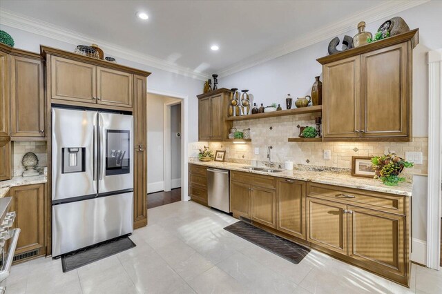 kitchen with light stone countertops, backsplash, stainless steel appliances, and sink