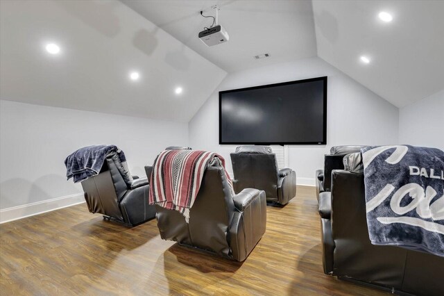 cinema featuring hardwood / wood-style floors and vaulted ceiling