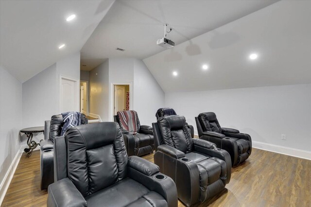 home theater with dark hardwood / wood-style floors and vaulted ceiling