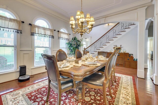 dining area featuring hardwood / wood-style floors, a notable chandelier, and crown molding