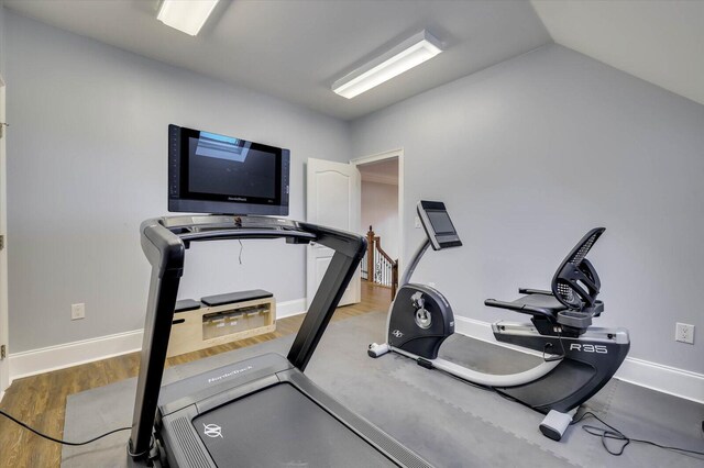 workout room with hardwood / wood-style floors and lofted ceiling