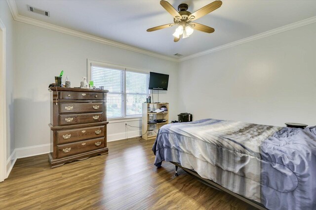 bedroom featuring crown molding, ceiling fan, and dark wood-type flooring