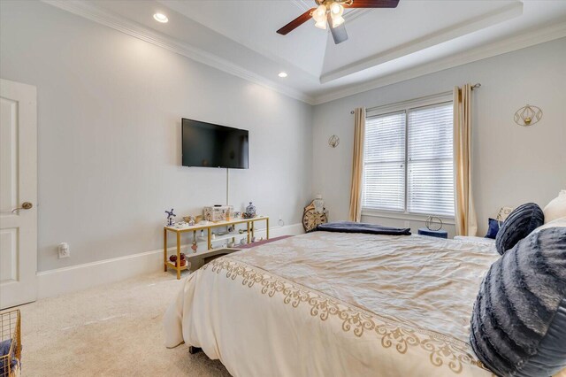 bedroom featuring a raised ceiling, ceiling fan, carpet flooring, and crown molding