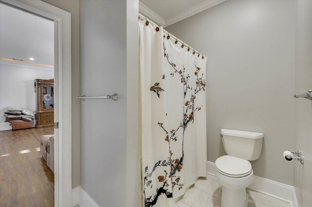 bathroom with toilet, tile patterned flooring, and ornamental molding